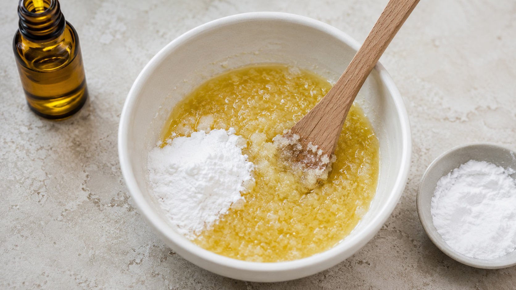 Bol montrant une pâte granuleuse d’huile dorée et de bicarbonate blanc